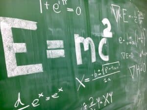 formulas on chalkboard including E=mc2