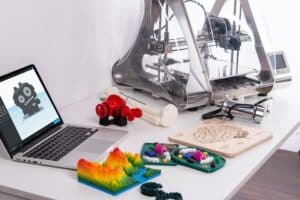 3d printer with objects and laptop