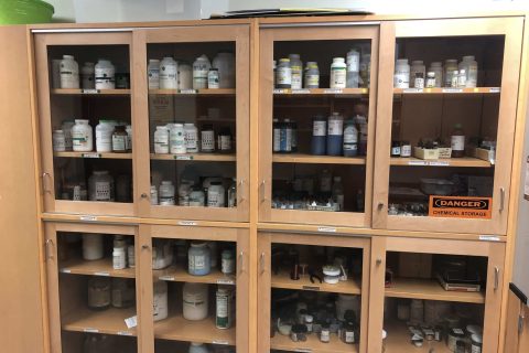 Science lab cabinets with chemicals. View during a safety inspection.